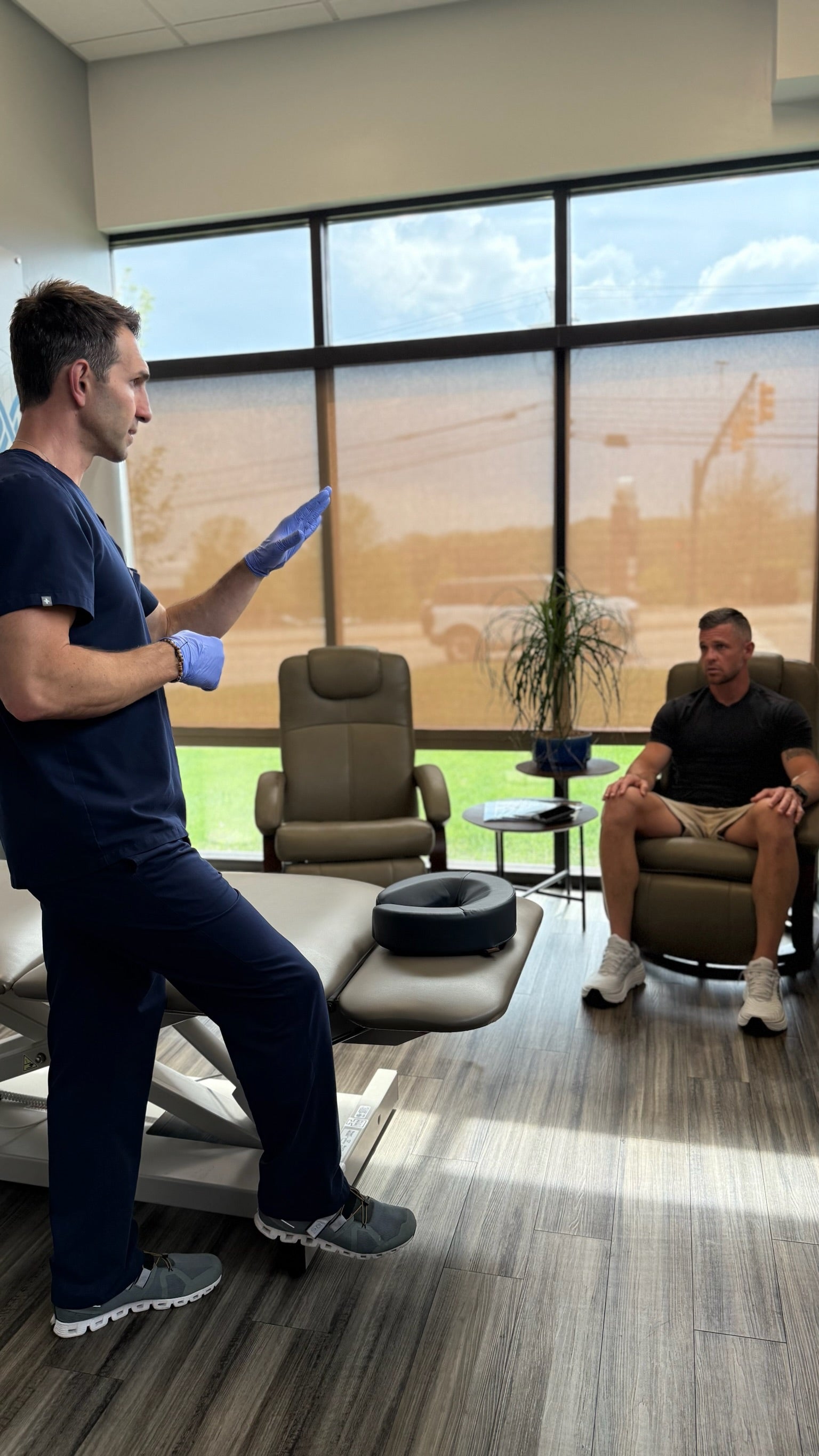 Two men in a modern office setting with large windows.