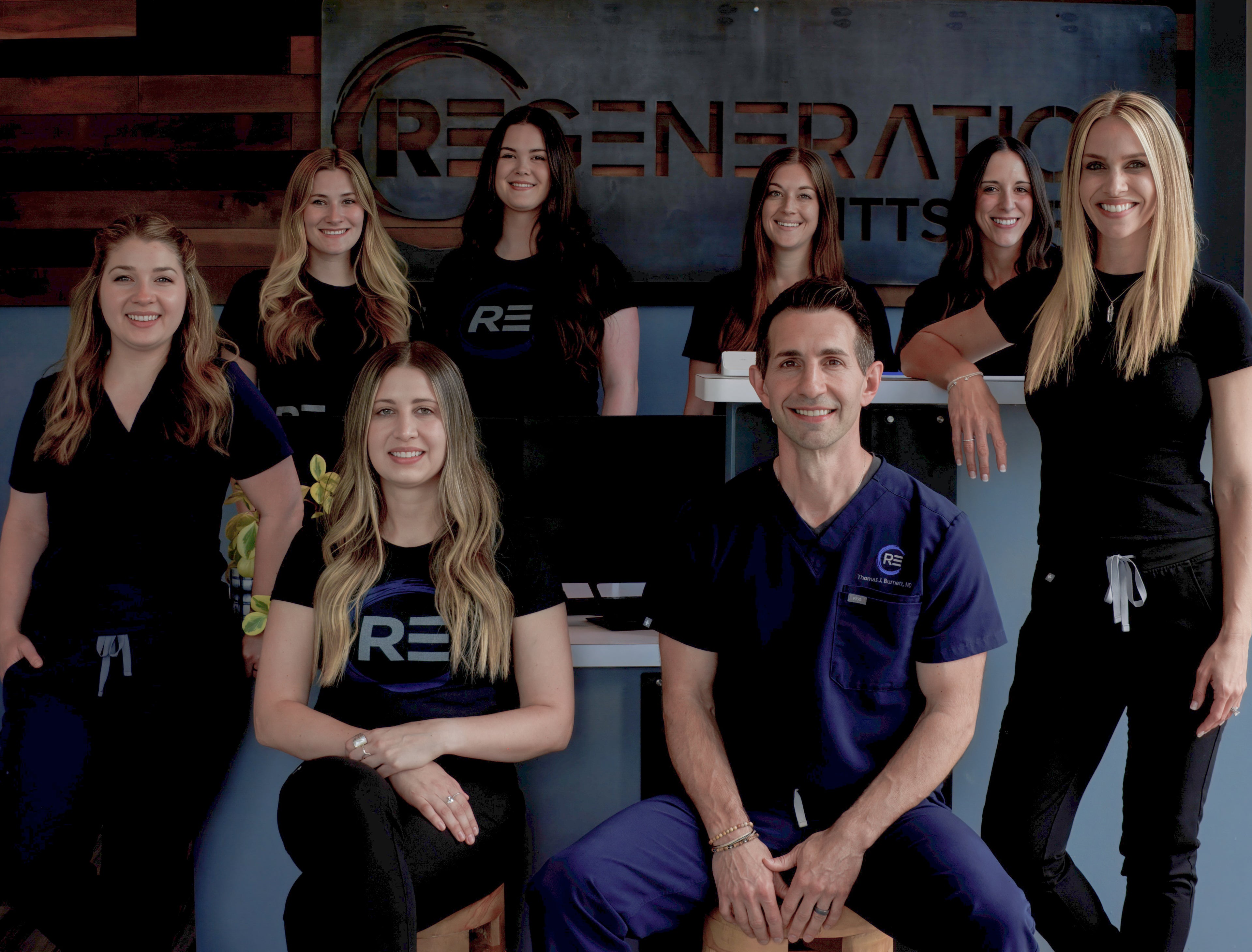 Group of people posing in front of a 'Regeneration Chirps' sign.