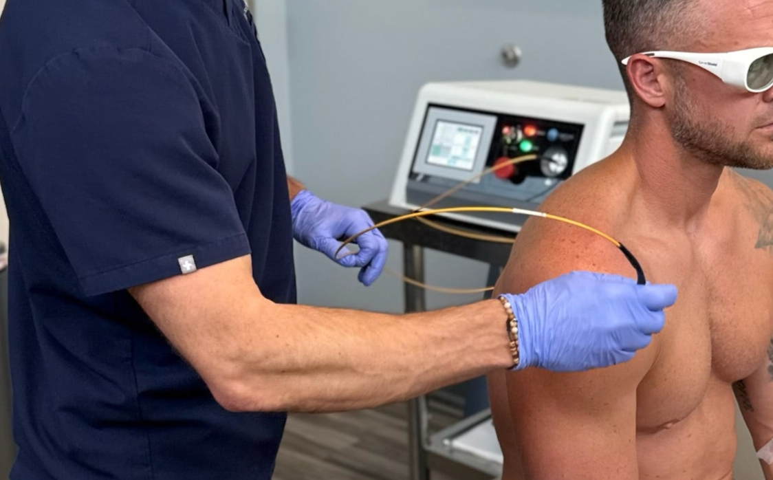 Physiotherapist treating a patient with a machine in a clinical setting
